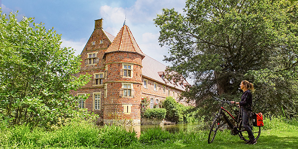 .Radfahrer vor dem historischen Haus Vögeding in Münster.
